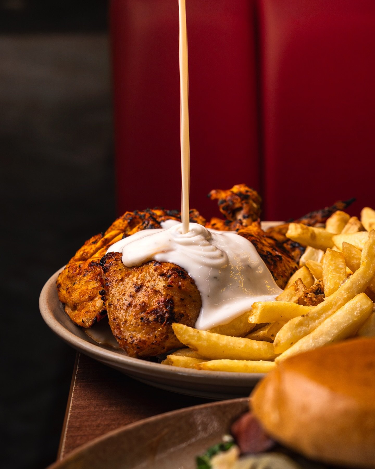Peri peri sauce poured over flame-grilled chicken at Manzanos